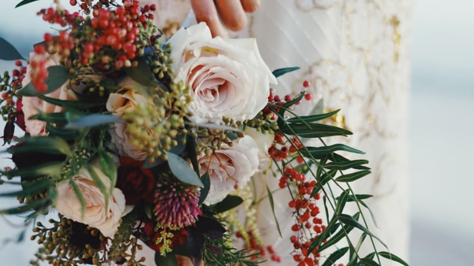 Blush roses and berries gathered in a hand-tied bouquet